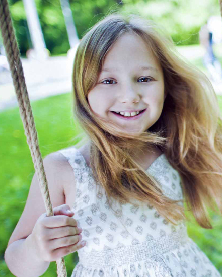 Little girl on swing smiling